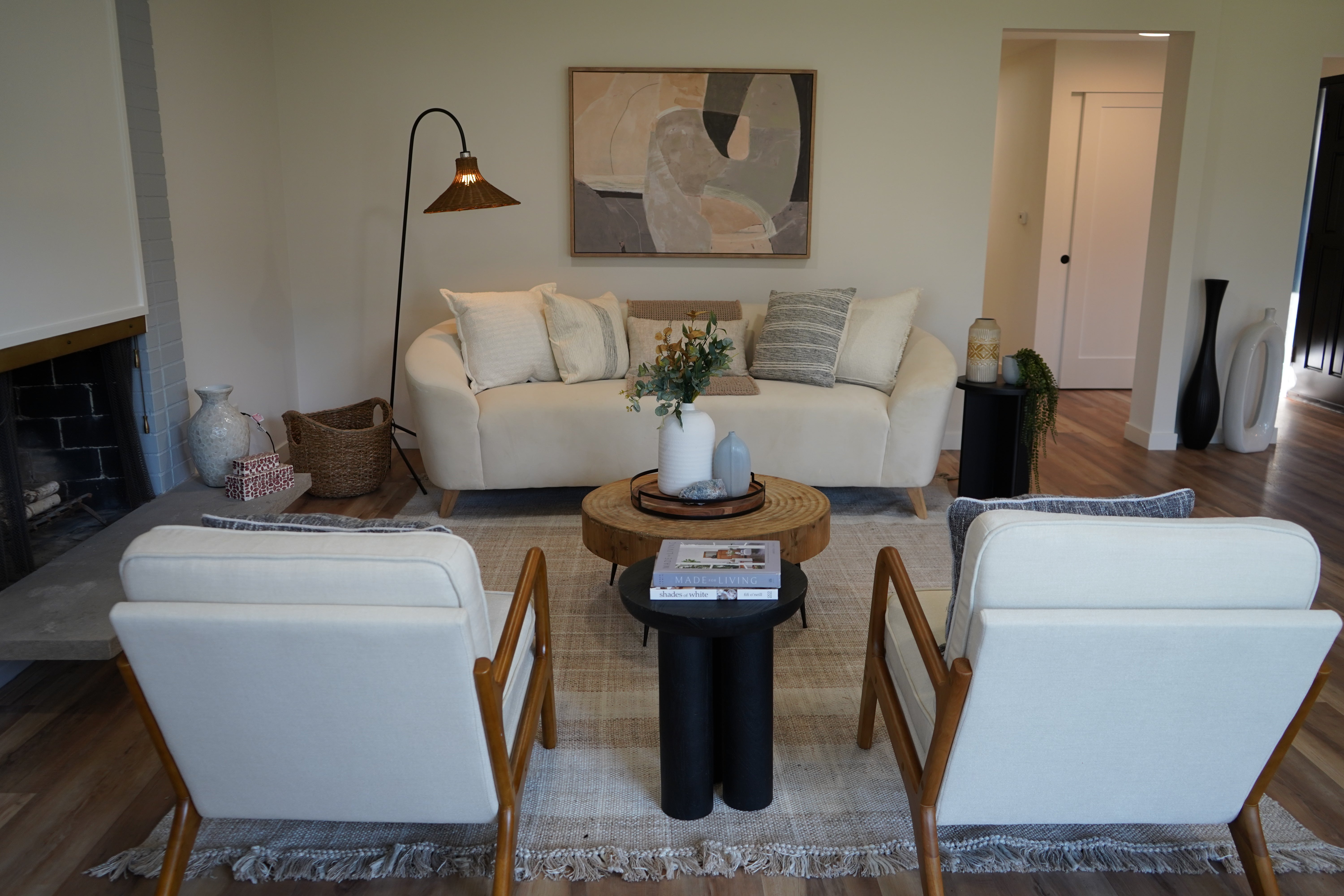 Living room with white sofa, chairs, and a coffee table with decor items.