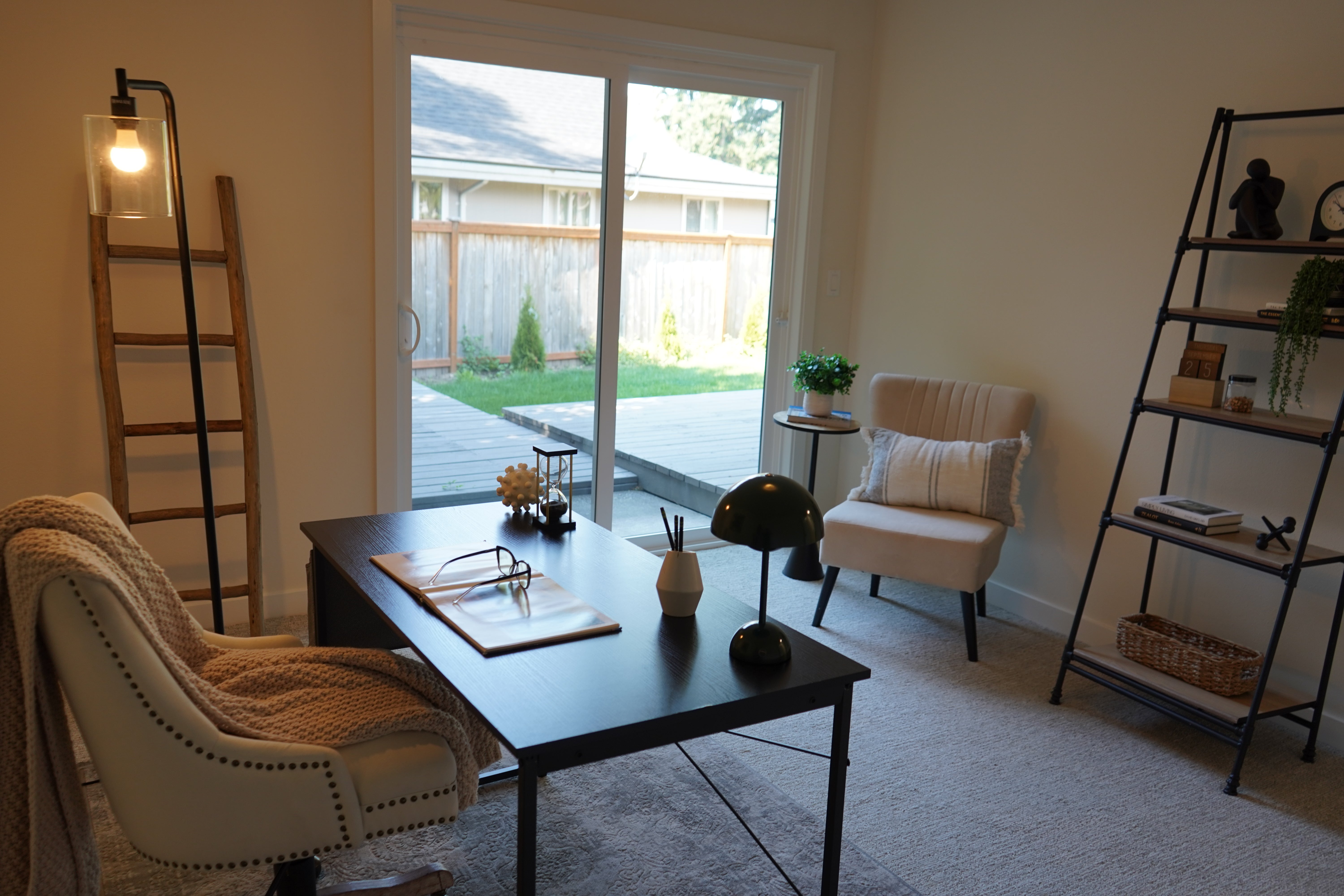 Living room with a coffee table, chairs, and a bookshelf.