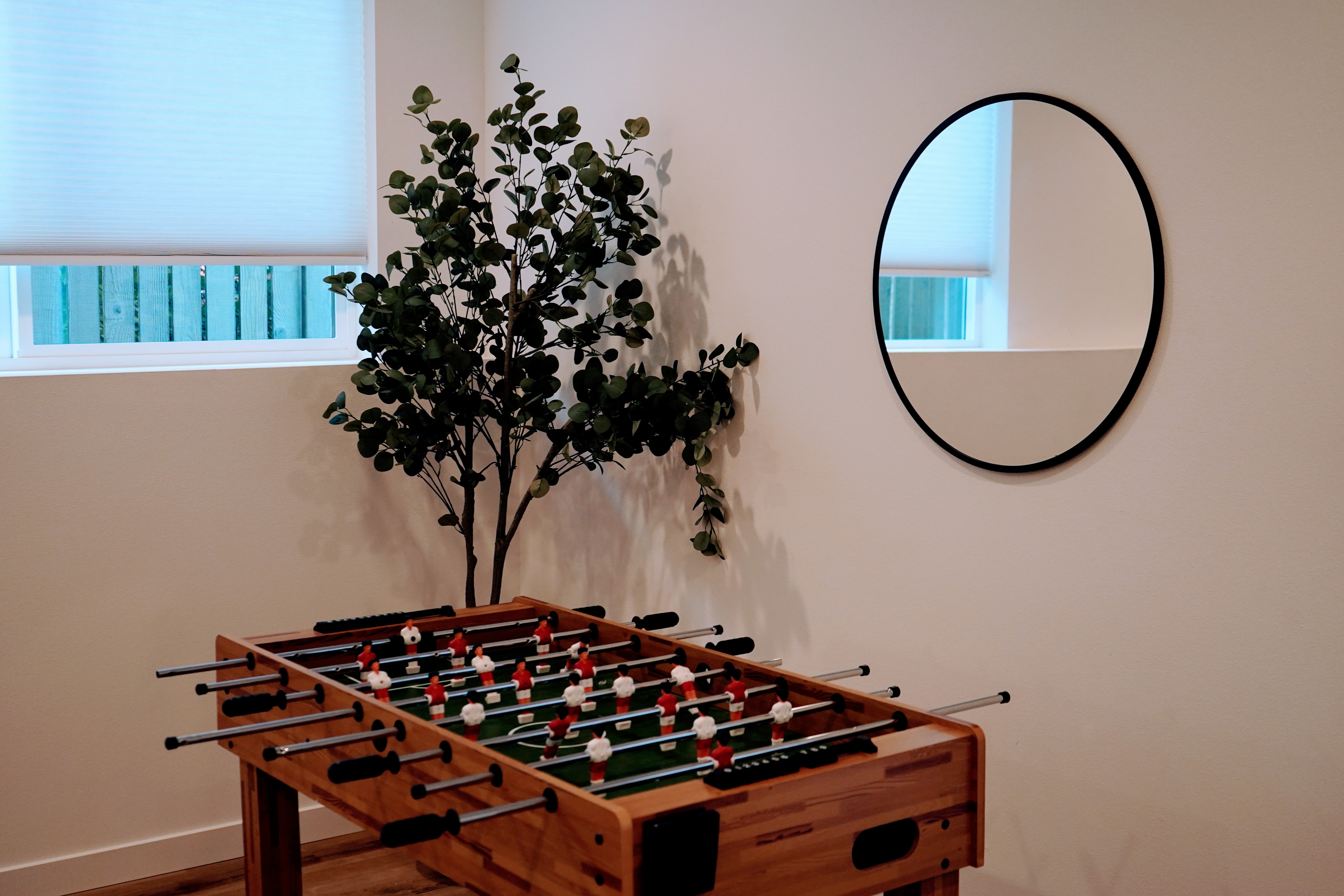 Foosball table in a room with a mirror and plant