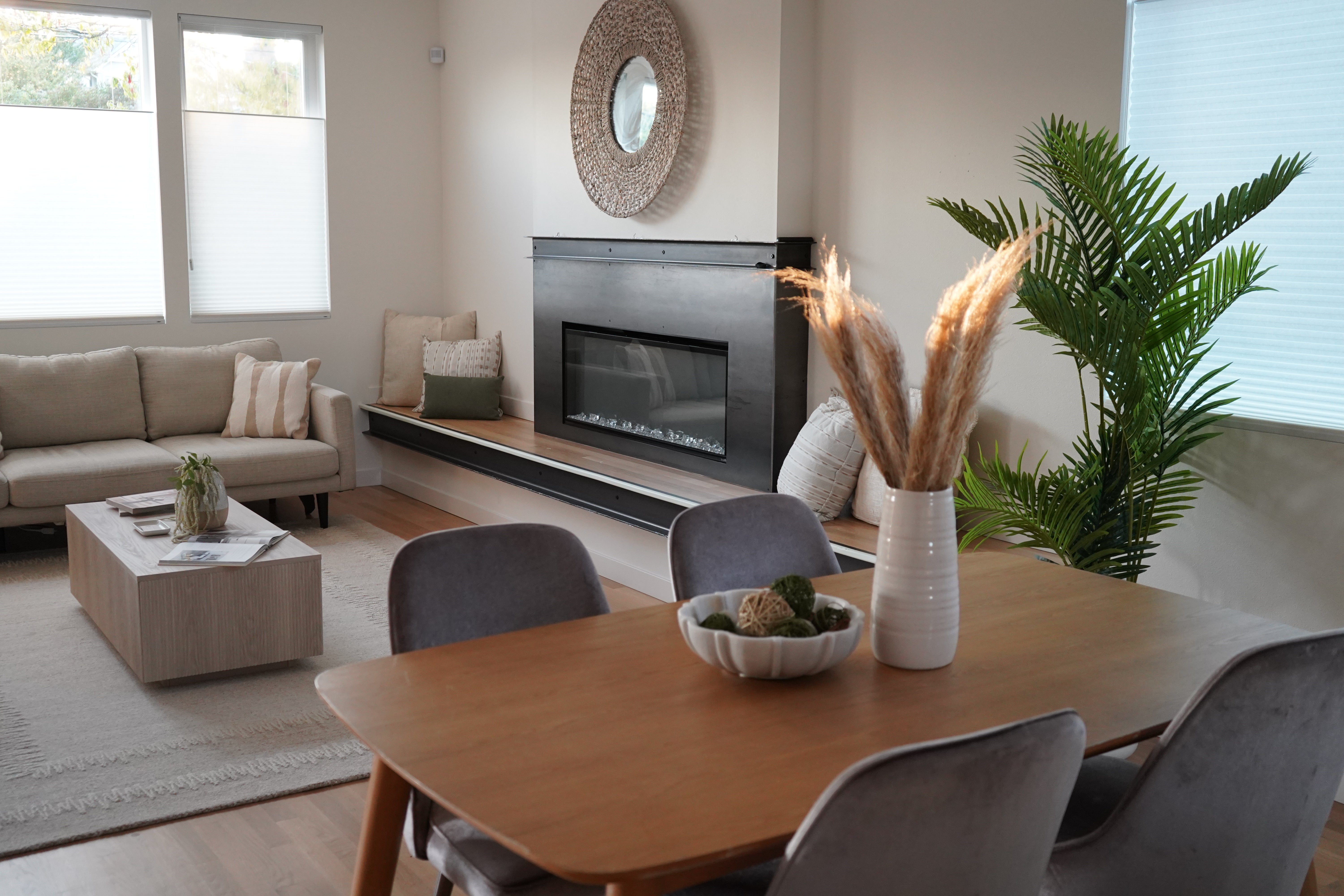 Modern living room with a fireplace, sofa, and dining table.