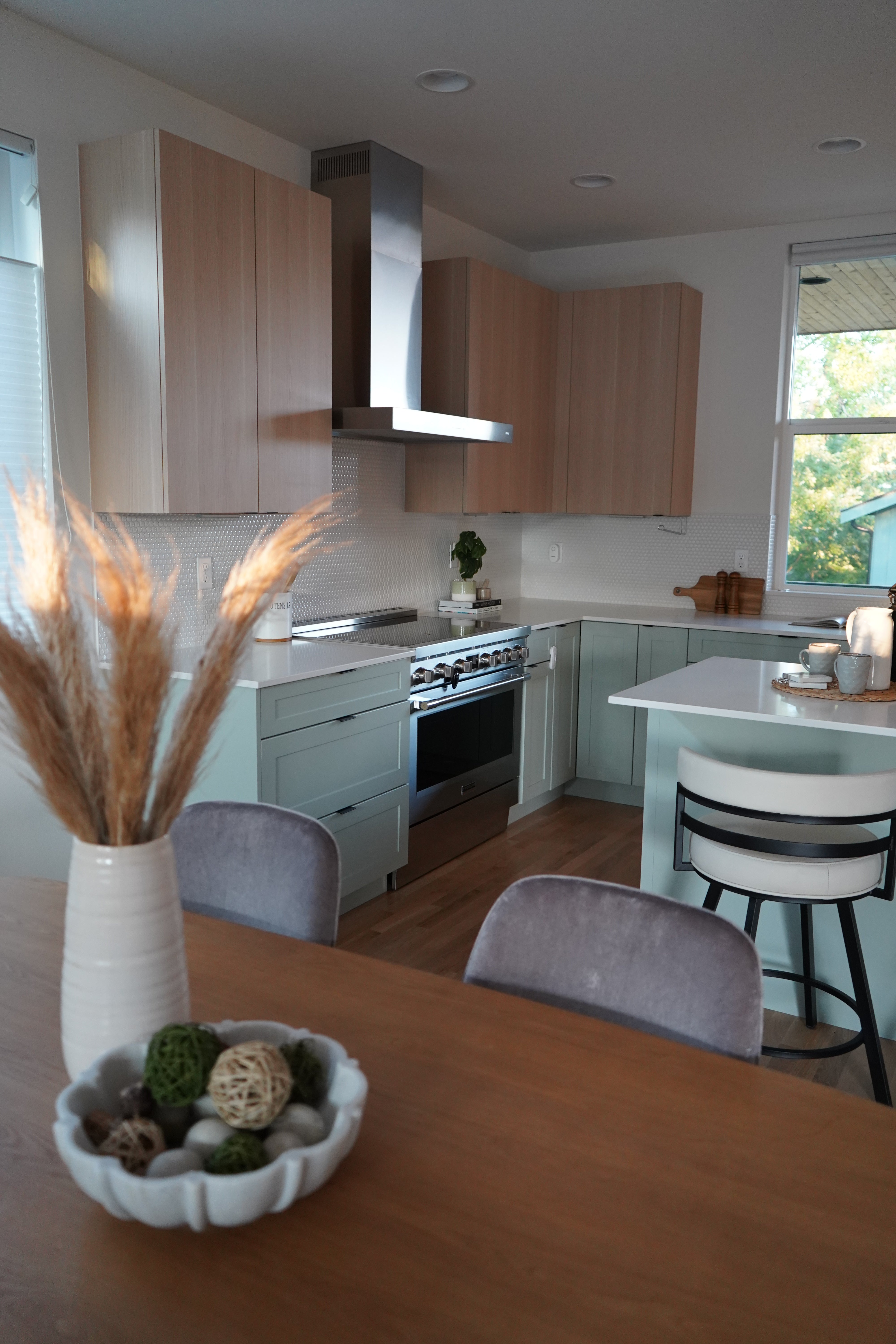 Modern kitchen with wooden island, bar stools, and white cabinets.