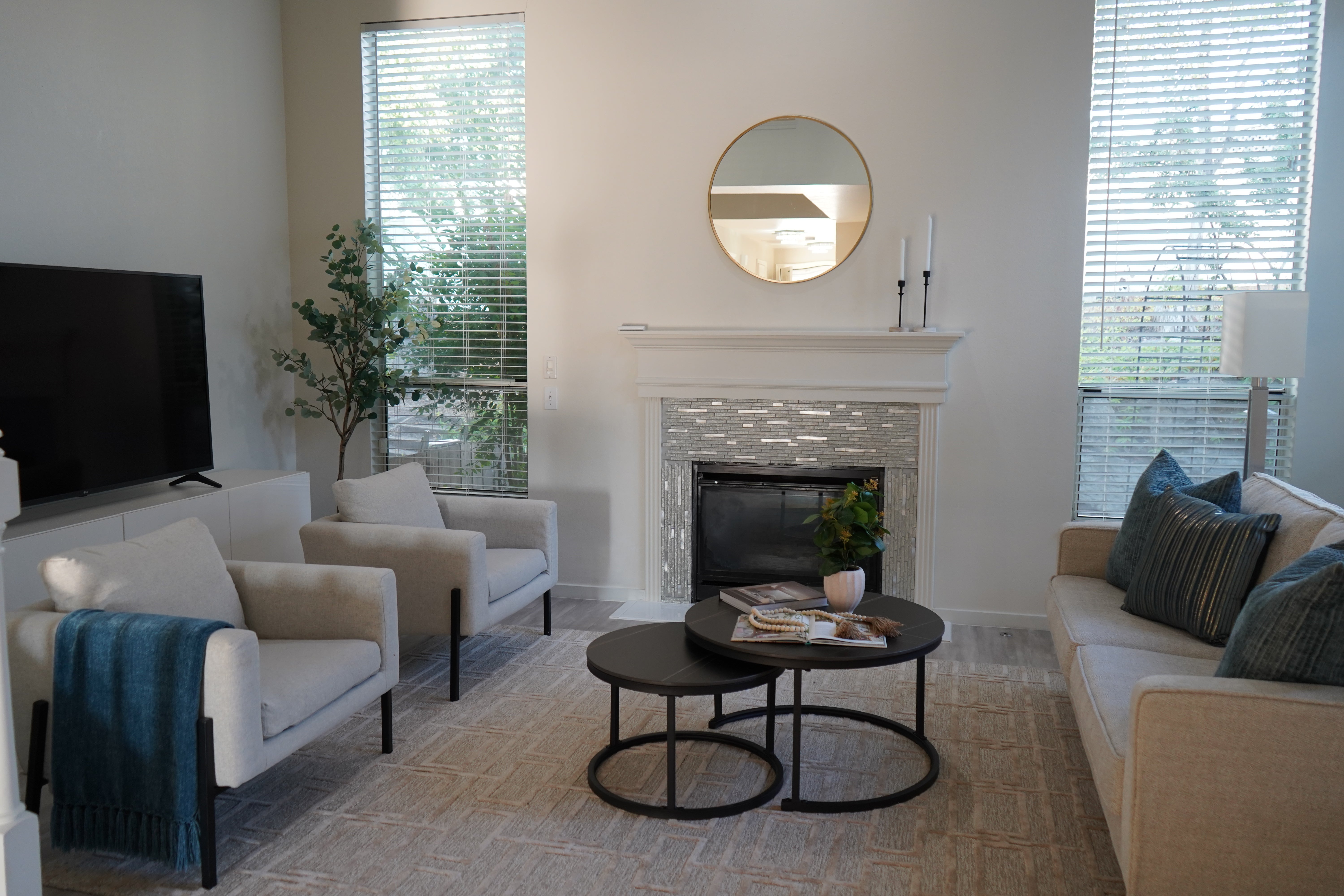 Modern living room with a fireplace, couches, and decorative items.