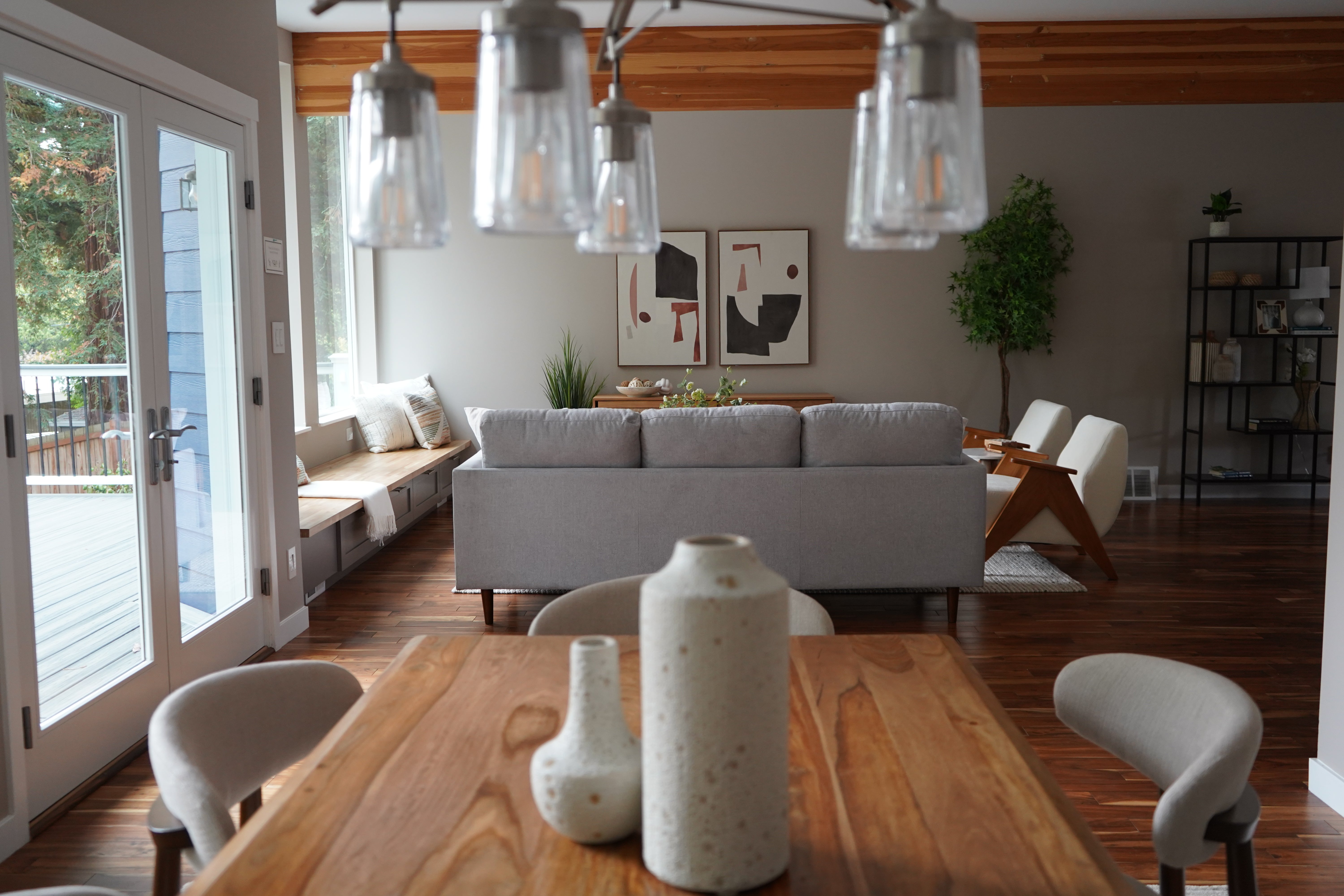Modern living room with a wooden table, chairs, and a gray sofa.
