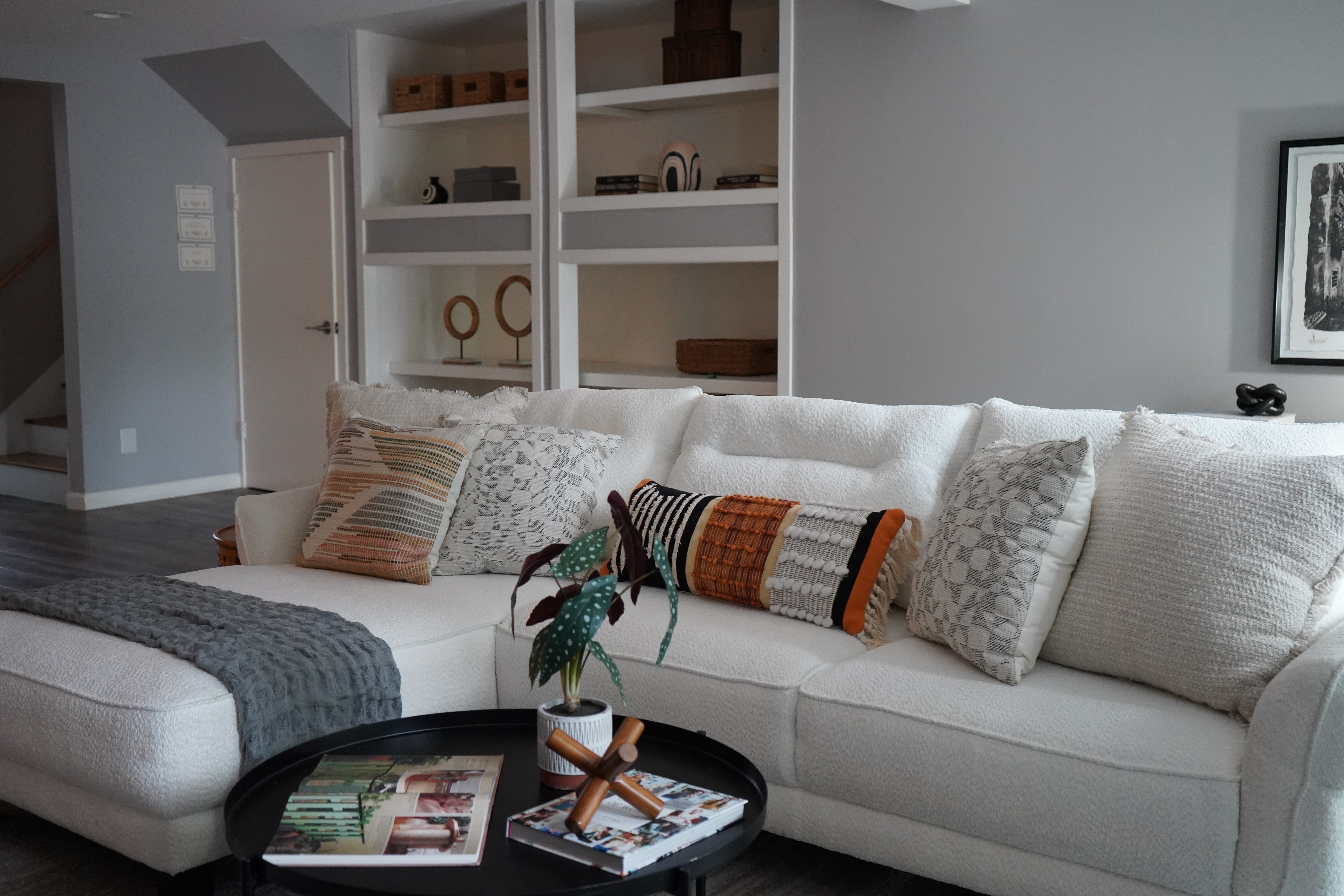 Living room with a white sectional sofa, decorative pillows, and a coffee table.