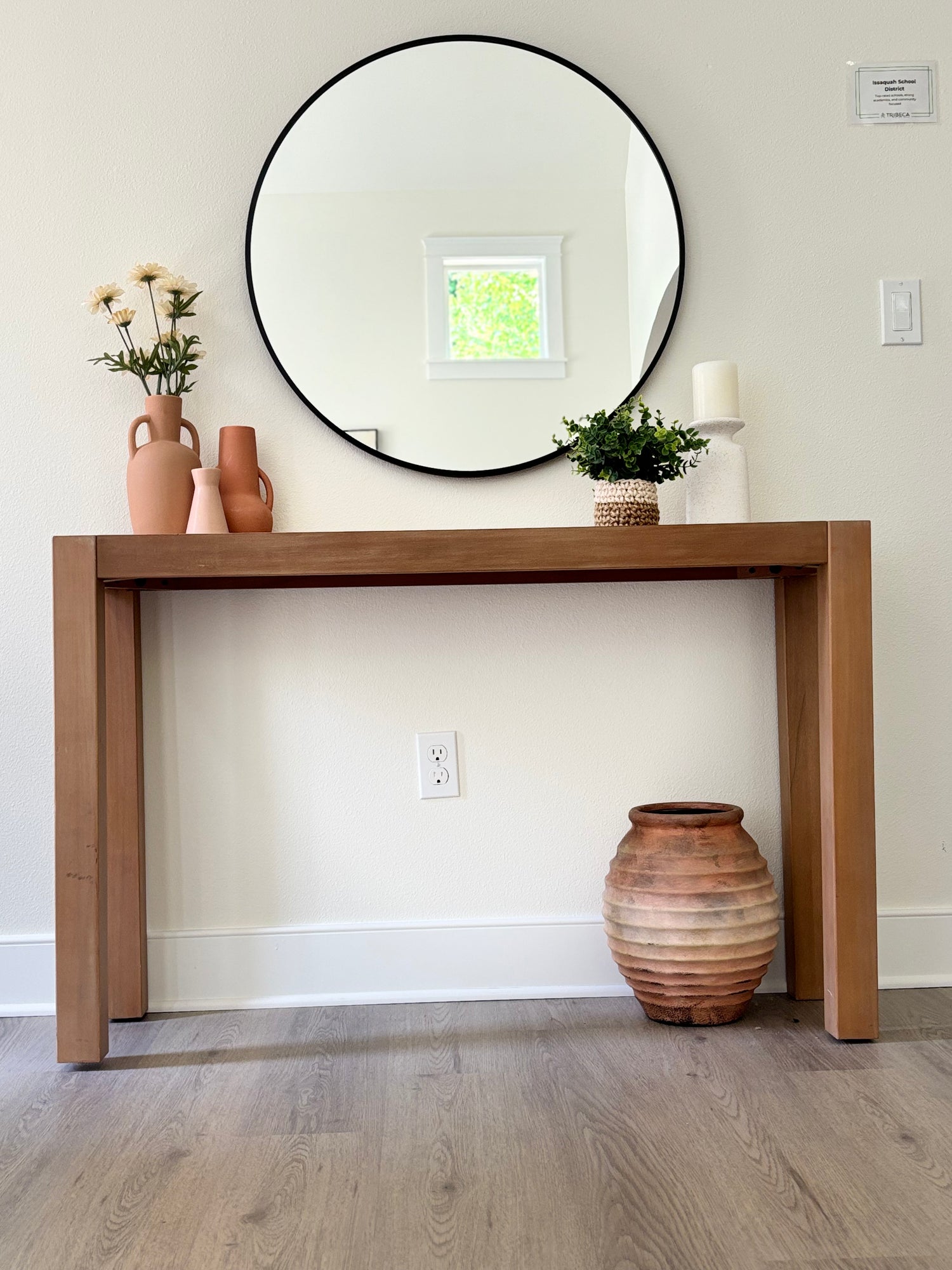 Wooden console table with decorative items against a wall
