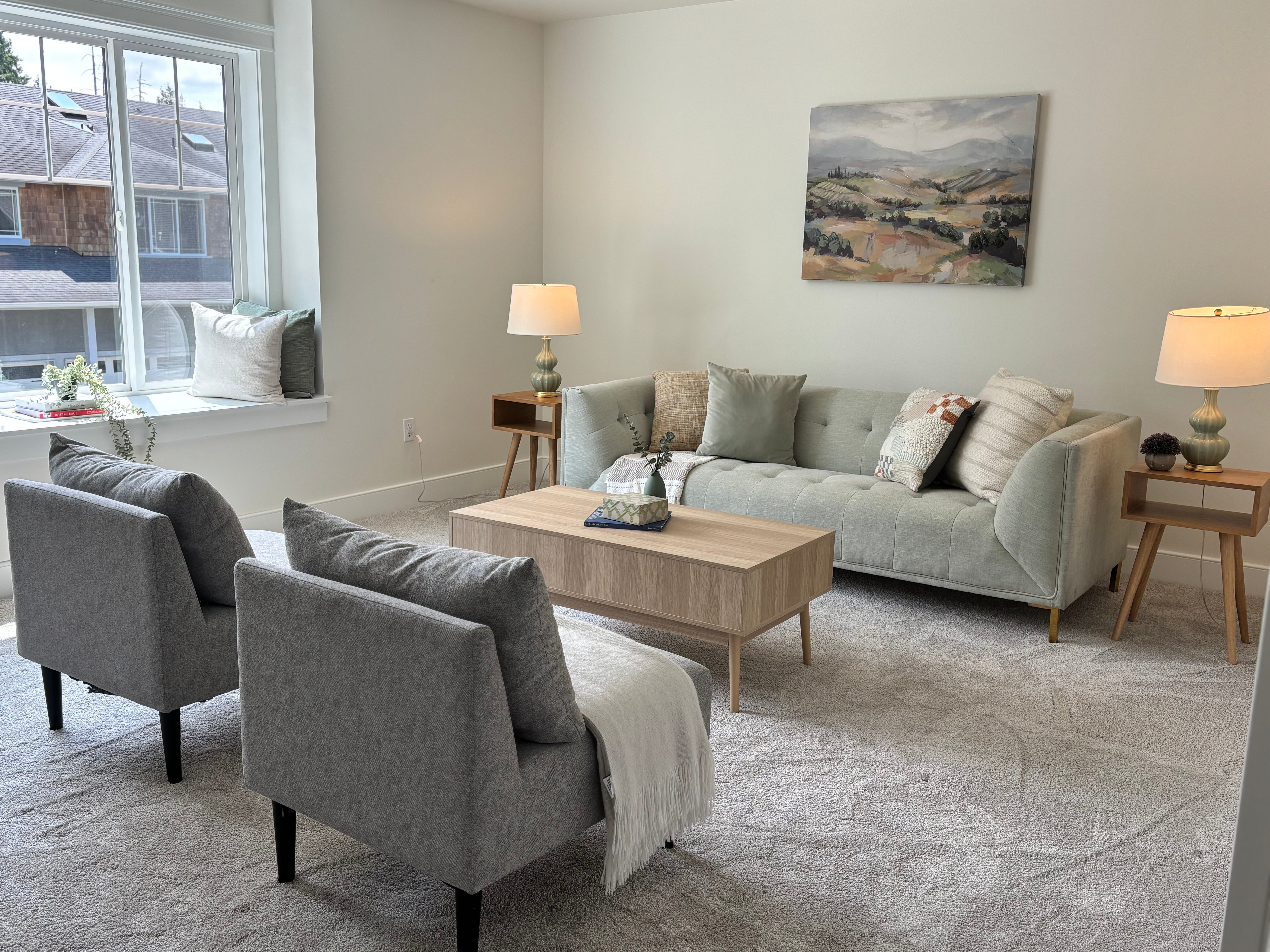 Modern living room with gray sofa, armchairs, and coffee table.